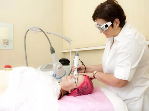 The cosmetologist performs laser rejuvenation procedure